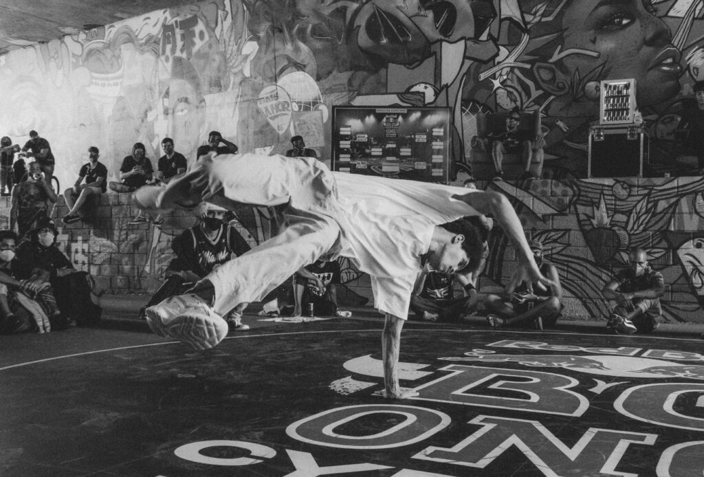 Energetic breakdancer performing on a vibrant graffiti street, capturing the essence of urban culture.